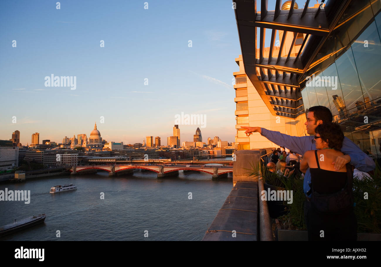 UK London Couple looking out over the river thames to st Pauls and the City Skyline Stock Photo