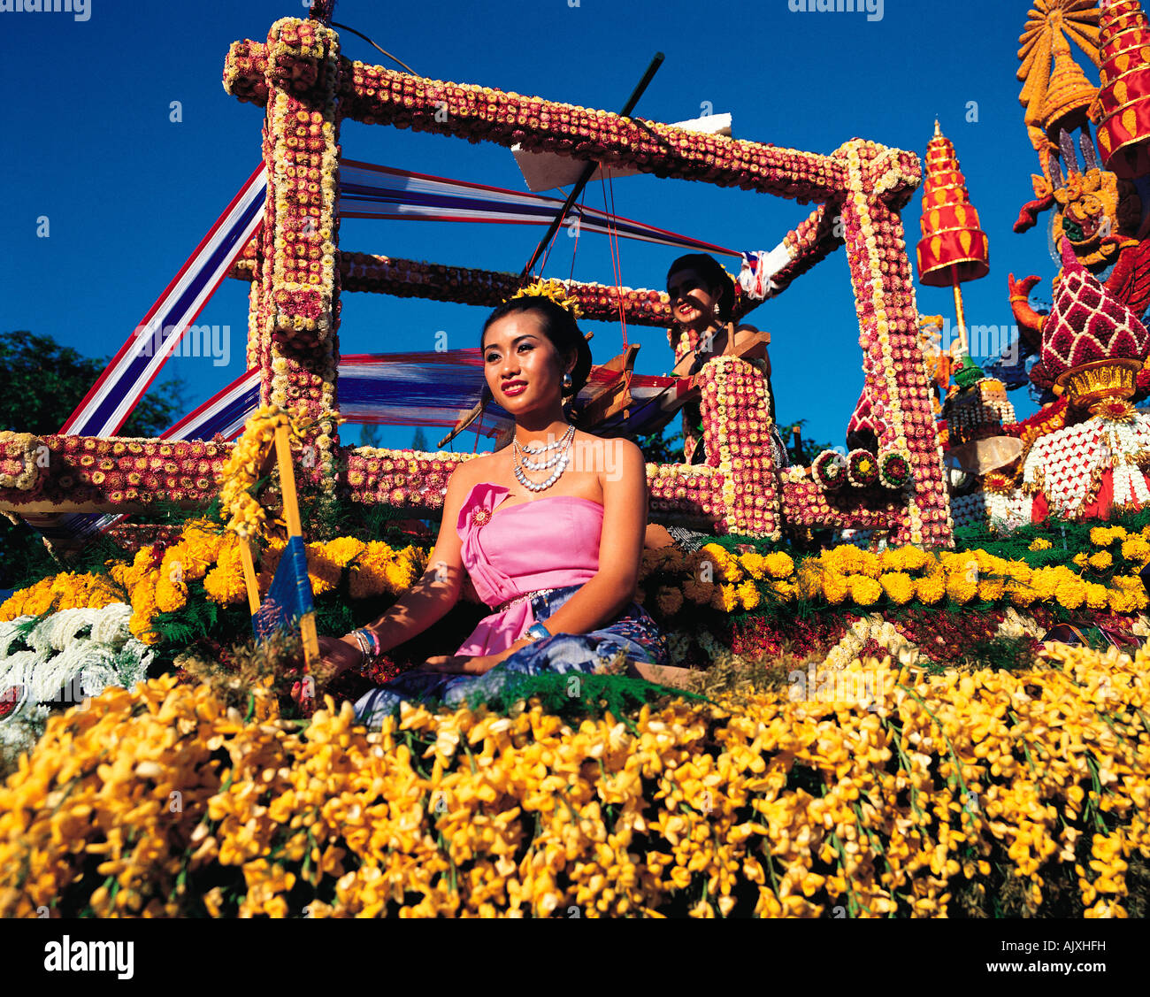 Thailand. Bangkok. Silom Road Festival parade. Beautiful Thai woman sitting amidst flowers on carnival float, Stock Photo