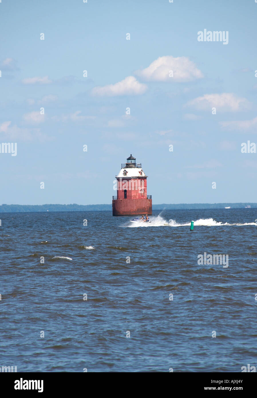 Light house on the Chesapeake Bay in Md with a jet ski passing in front