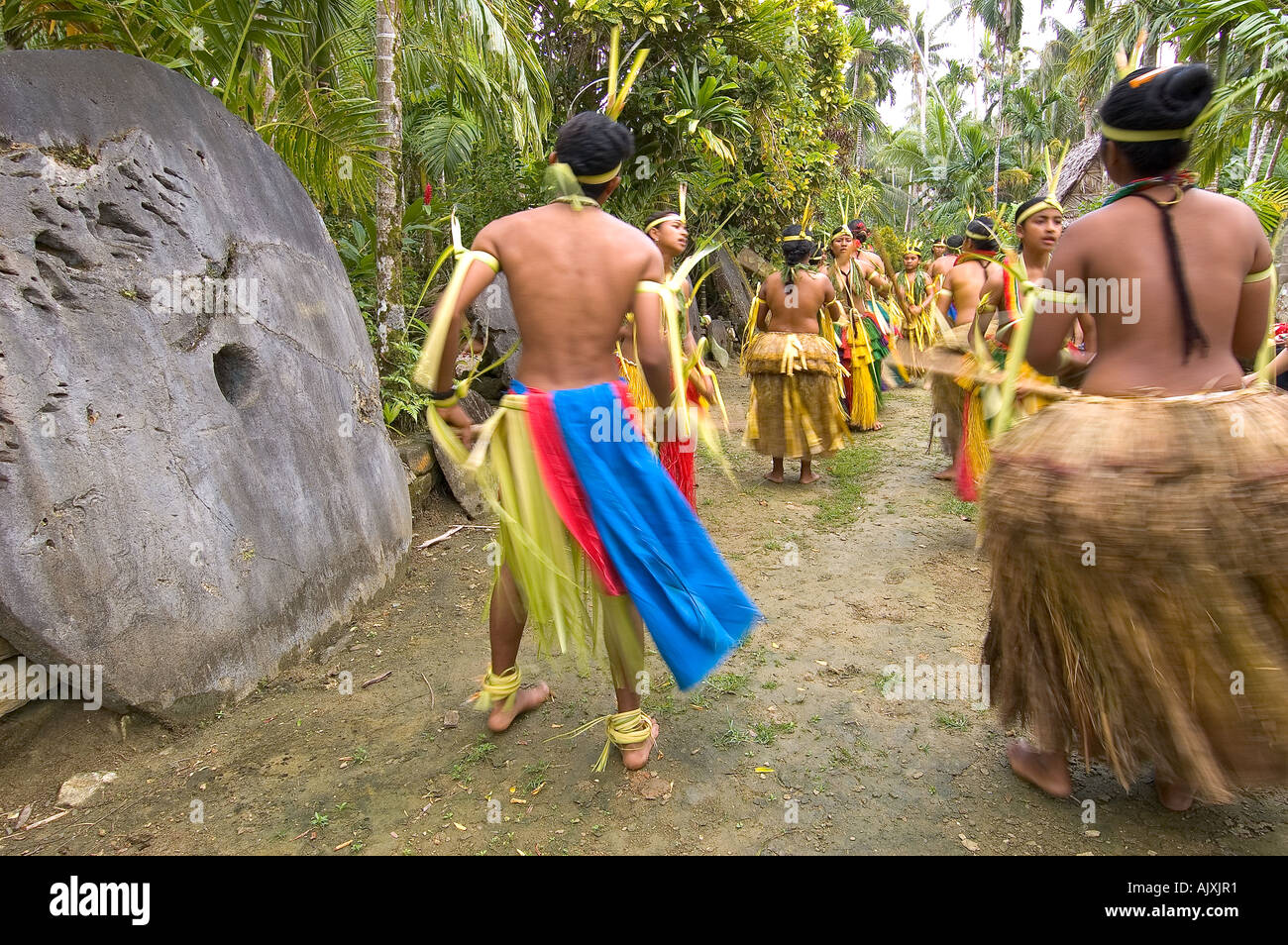 Yapese traditional dancers performing Stick Dance in front of Stone Money Yap Micronesia Pacific Ocean Stock Photo