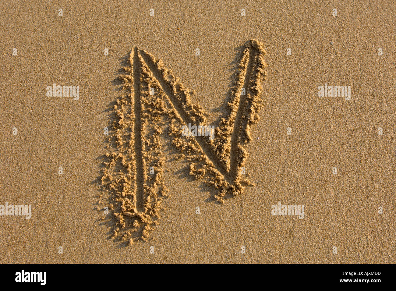 Alphabet hand writen letters on the sand Stock Photo