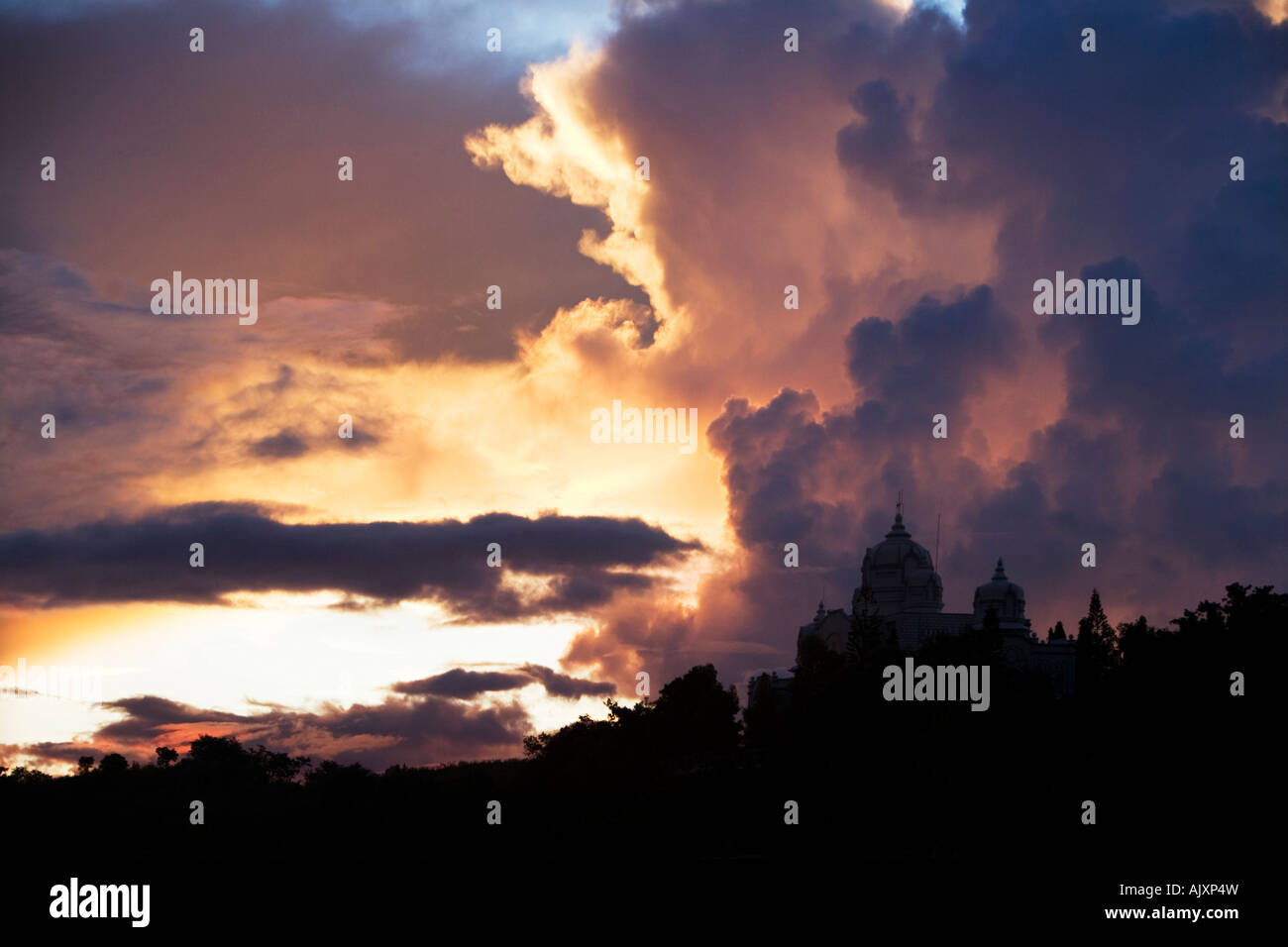 Sunset storm clouds over Indian ashram buildings. Puttaparthi,  Andhra Pradesh, India Stock Photo