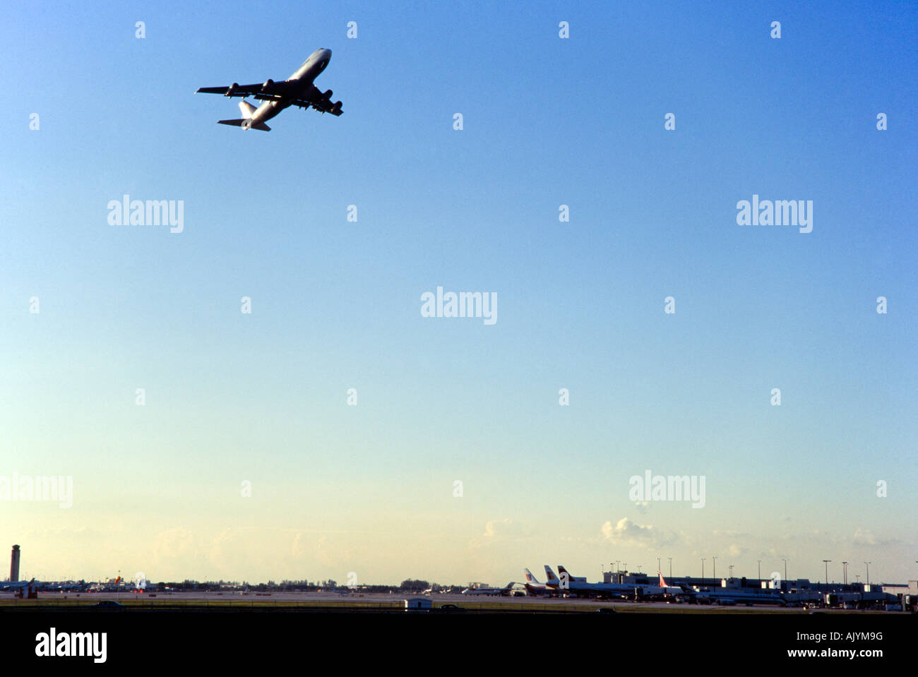 Commercial Airliner takeoff at dusk, over airport, Miami International Airport Stock Photo