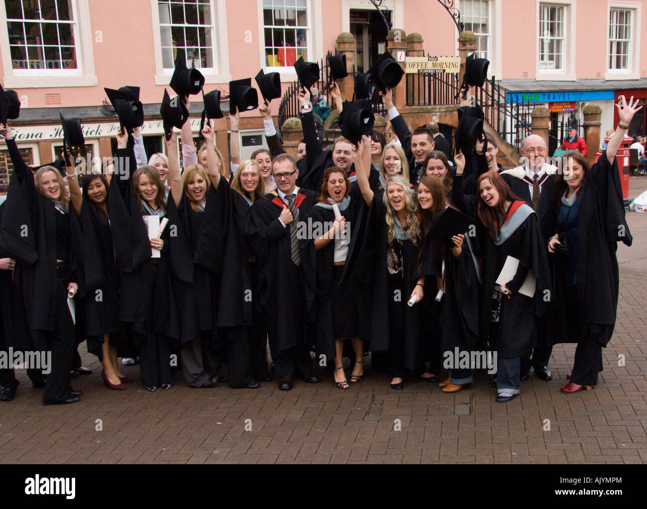 Group of happy student and staff throwing hats into air after graduation ceremony University of Cumbria Carlisle England Stock Photo