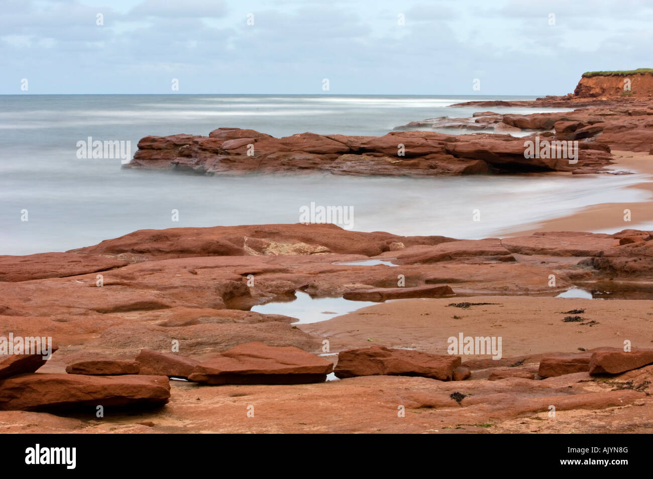 Red rocks and surf along Campbell's Cove beach, Campbell's Cove, PE/PEI Prince Edward Island, Canada Stock Photo