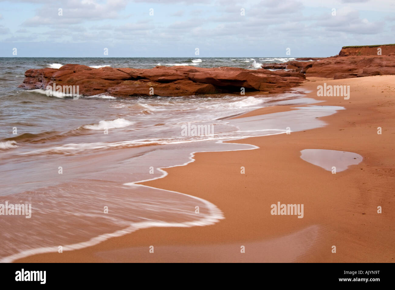 Red rocks and surf along Campbell's Cove beach, Campbell's Cove, PE/PEI Prince Edward Island, Canada Stock Photo