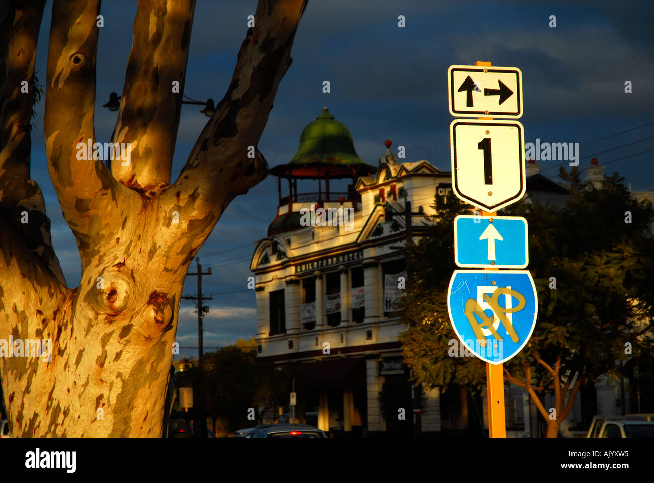 last light of sunset shines on highway street sign, sugar gum and Guildford hotel in background. Guildford, Western Australia Stock Photo