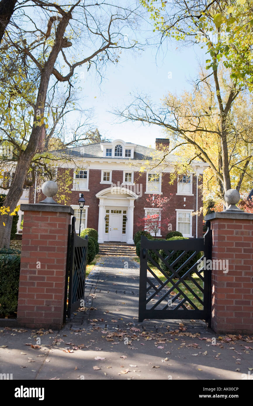 Gated walkway up to three story vintage brick house in the fall Stock