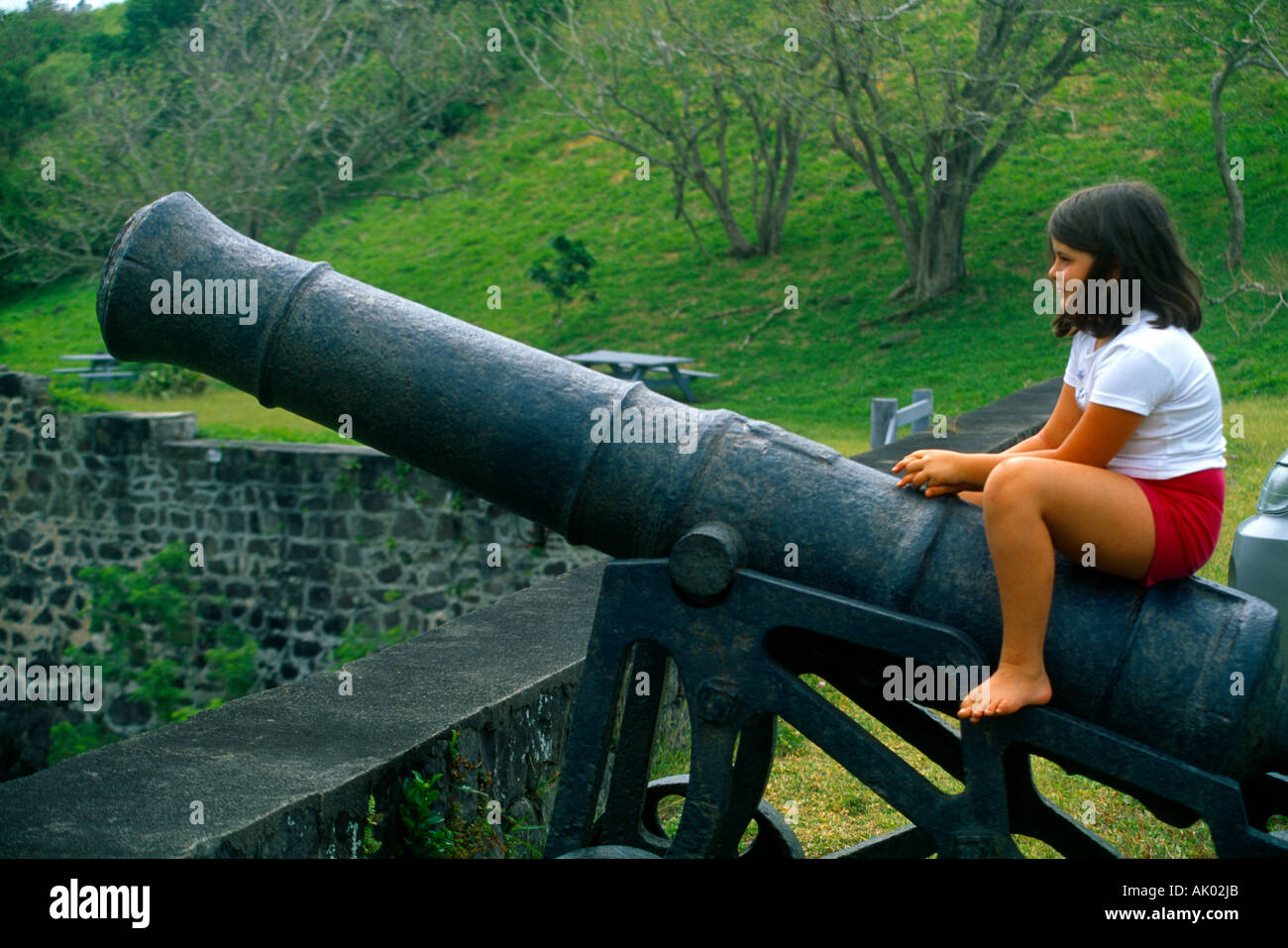 St Kitts Brimstone Fort World Heritage Site Girl Sitting on Cannon Stock Photo