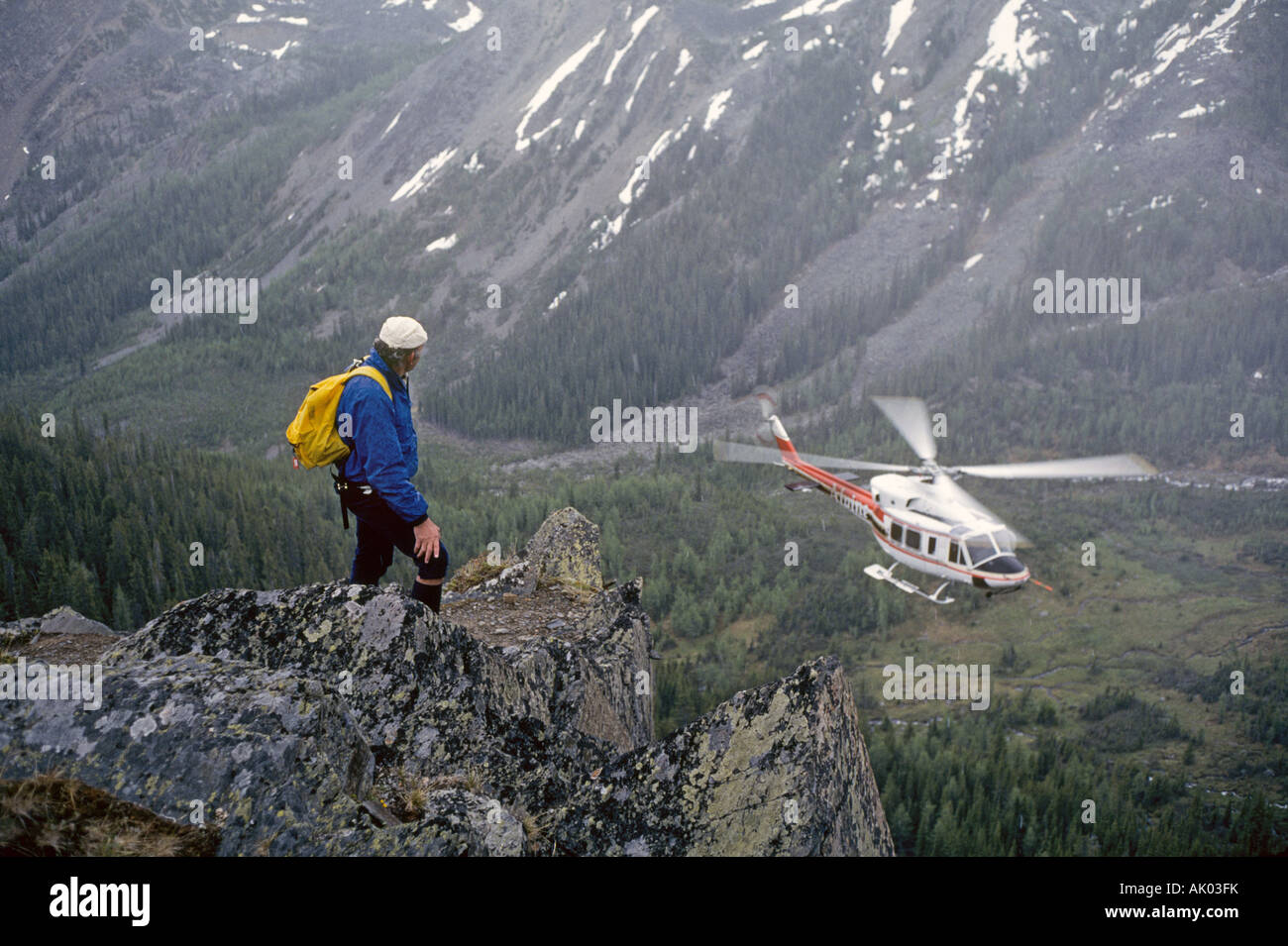 A helihiker takes in the view in the Bugaboo Mountains in British Columbia Stock Photo