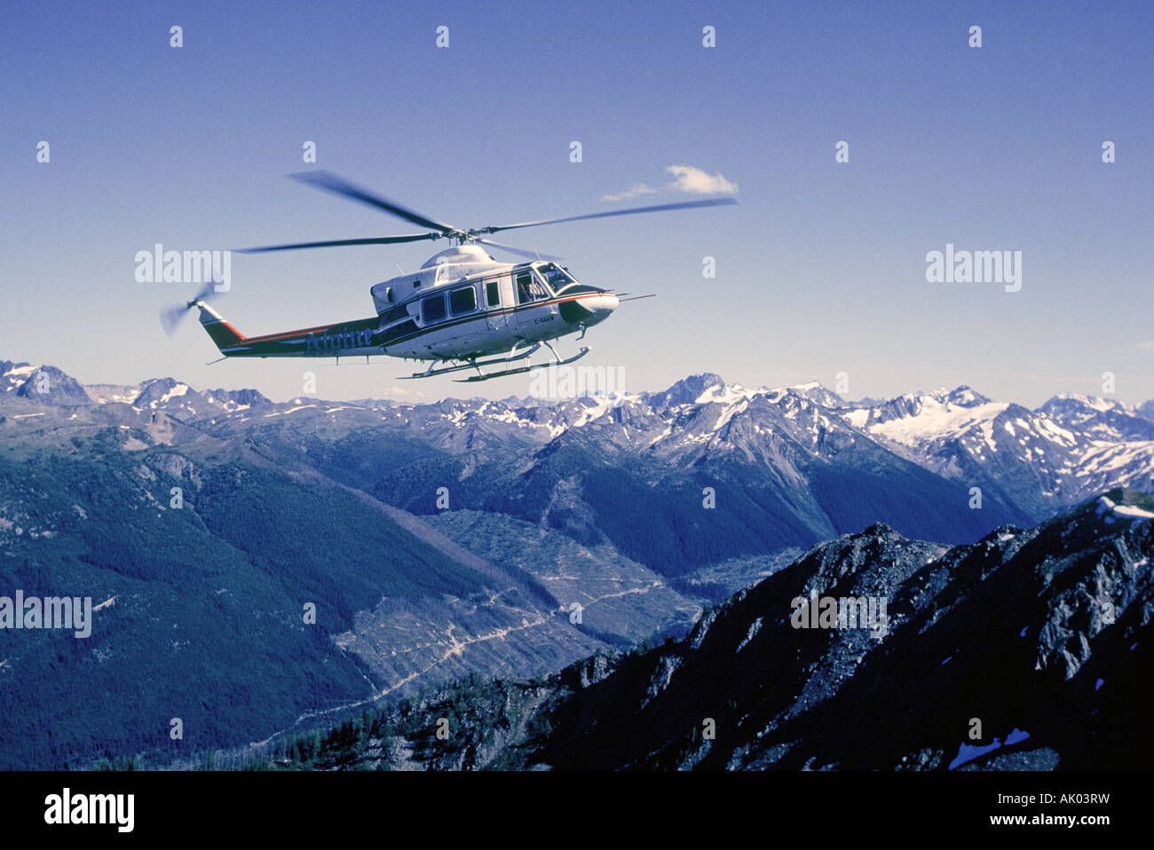 A helicopter carries hikers into the high country of the Bugaboo Mountains in British Columbia Stock Photo