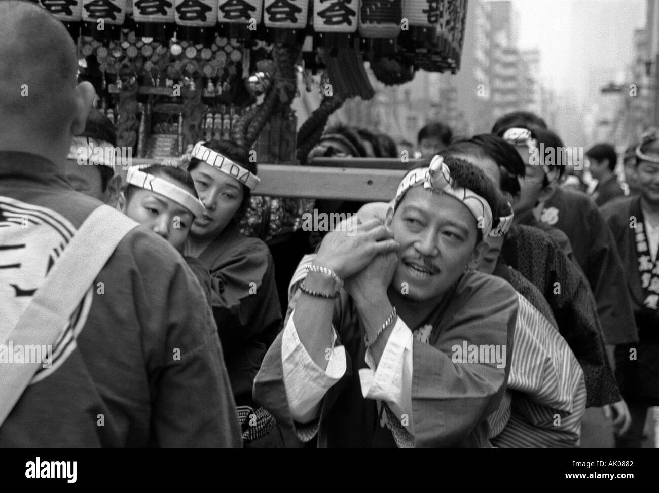 Group religious young men man boy woman celebrate march carry stall on shoulders Matsuri Festival Tokyo Japan Eastern Asia Stock Photo