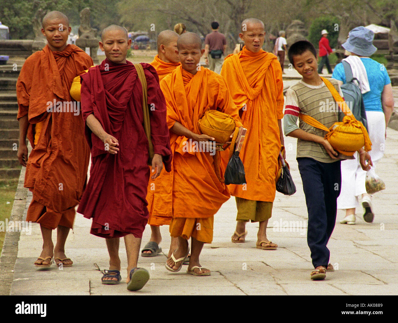 Group of young shaved head novices traditional colourful robe walk stoic march together Angkor Wat Cambodia Southeast Asia Stock Photo