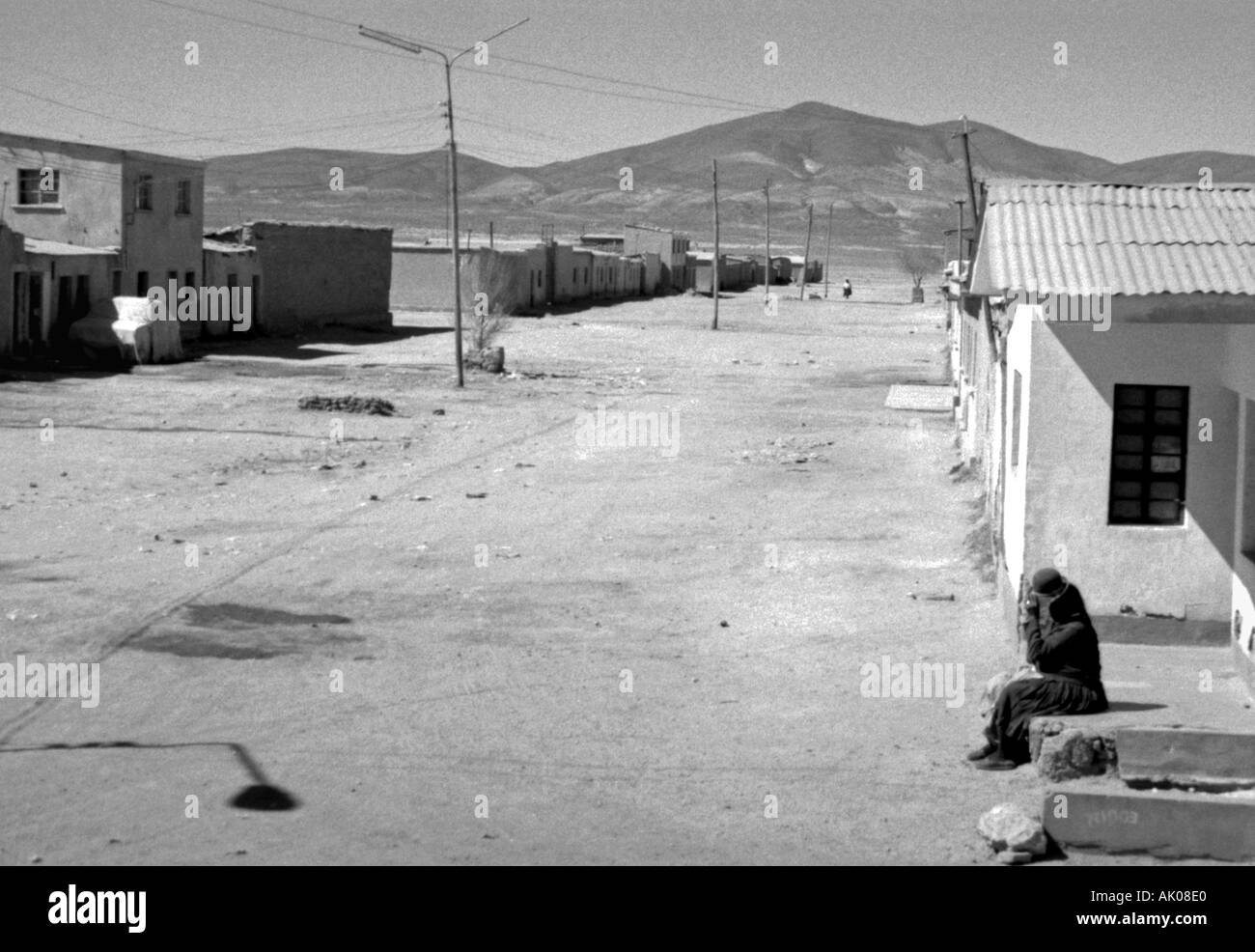 Panoramic view arid desert rural ghost town dust sun hot empty road woman Ujuni Uyuni Desert Bolivia South Latin America Stock Photo