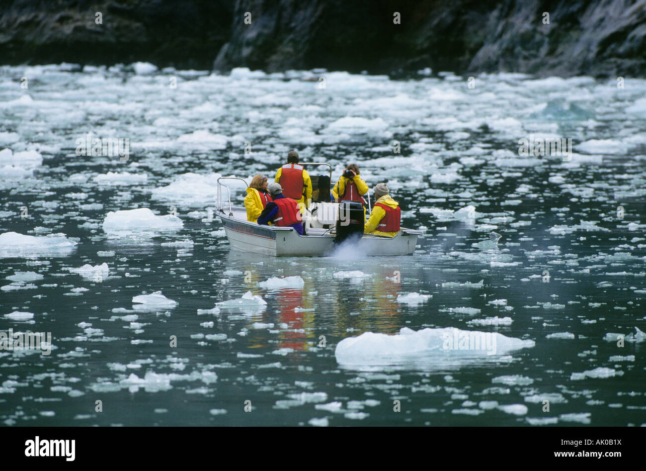 A small boat filled with visitors from a larger cruise ship navigates