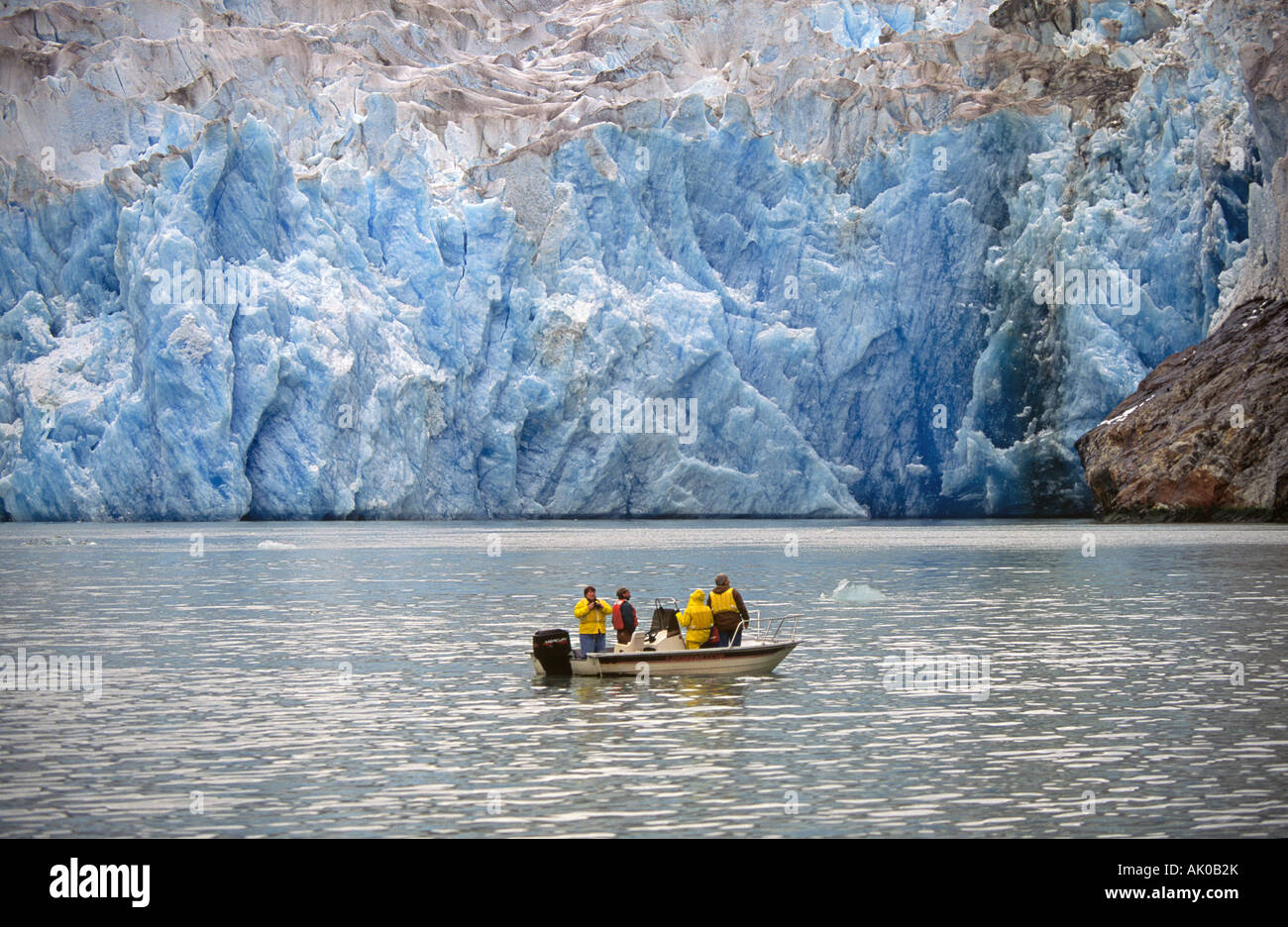 A small boat filled with visitors from a larger cruise ship navigates
