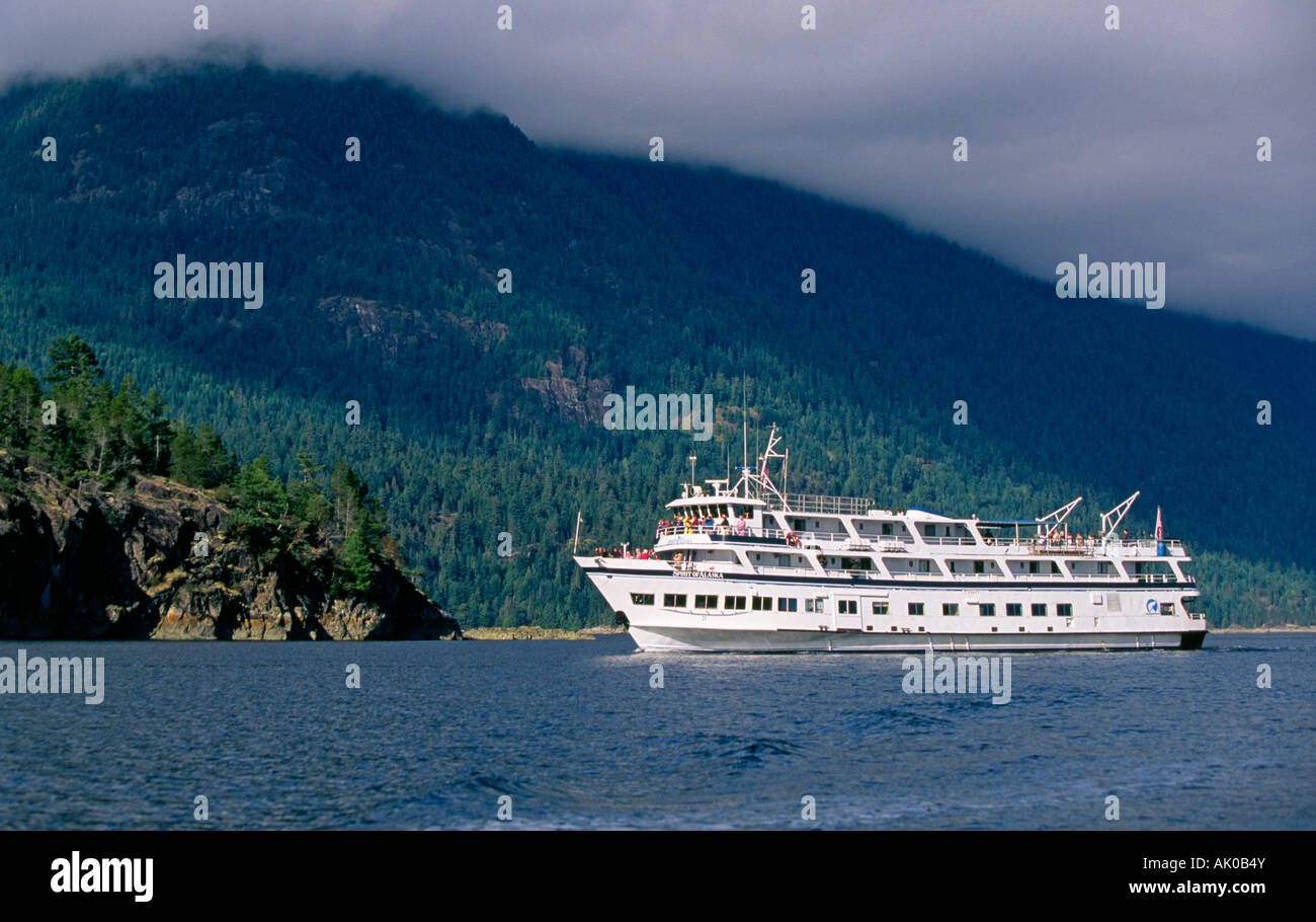 A small cruise ship navigates the bays and straights of the Inside Passage This is in British Columbia Stock Photo