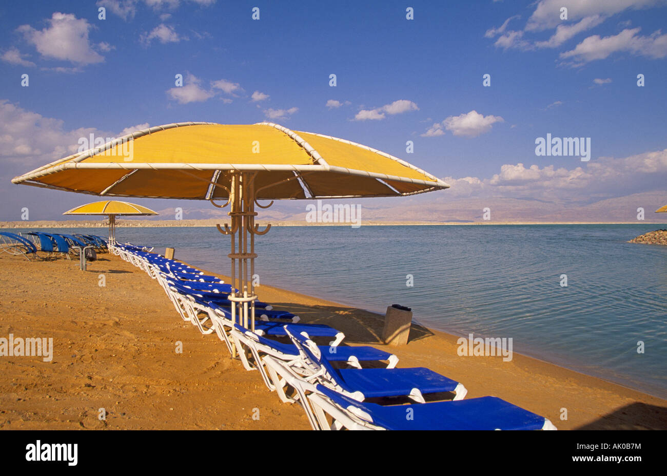 MIDDLE EAST ISRAEL Beach umbrellas and chairs along the shore of the Dead Sea in the hotel district Stock Photo
