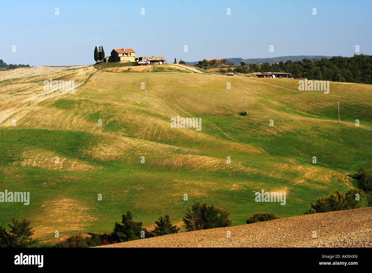Classic iconic Tuscany farm house sits on hill top with rolling golden ...