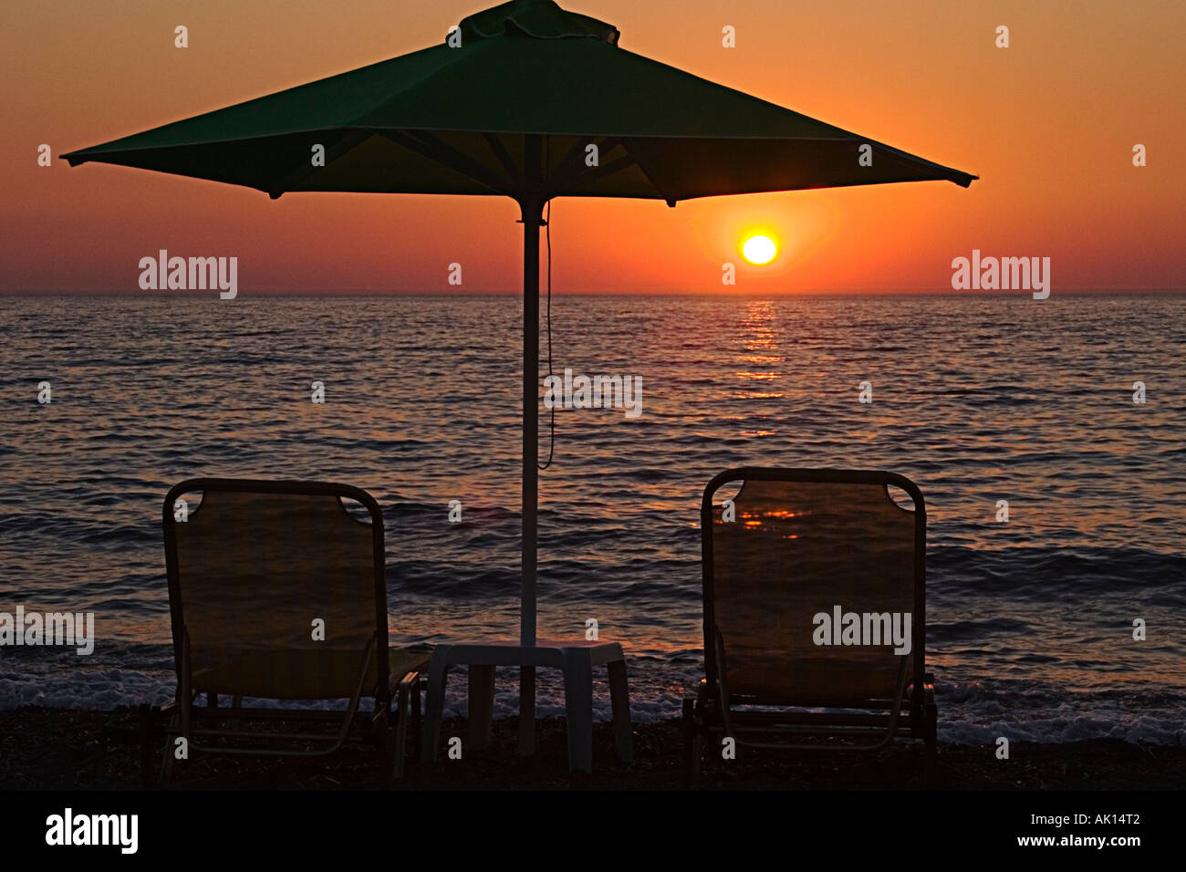 Sunset with beach umbrella and sun loungers, Anaxos beach, Lesvos, Eastern Agean, Greek Islands, Greece Stock Photo