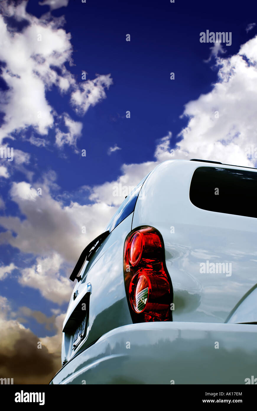 Back of modern SUV against impressive sky with clouds Stock Photo