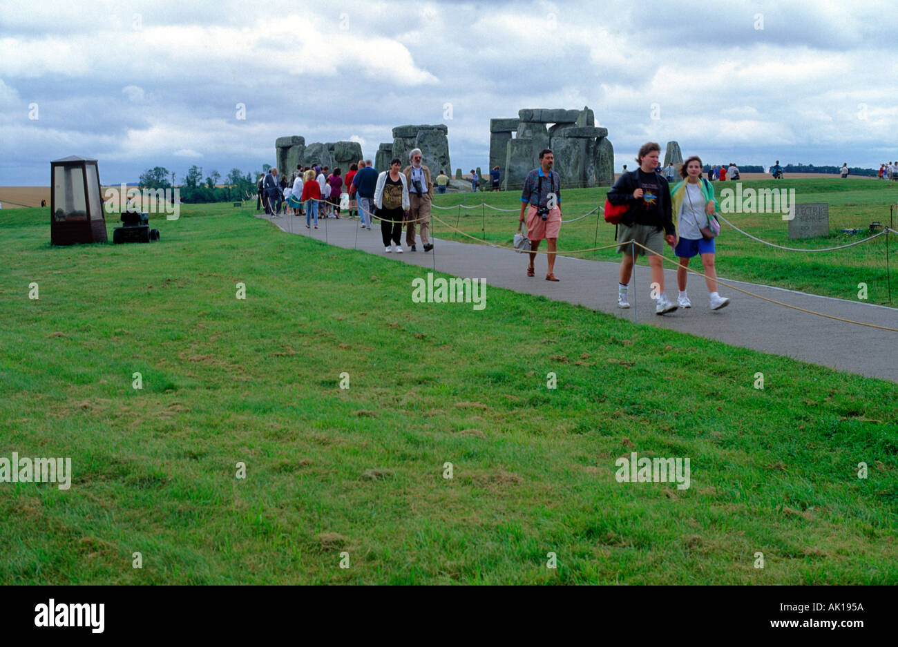 Tourists on a paved path at Stonehenge Wiltshire England Stock Photo