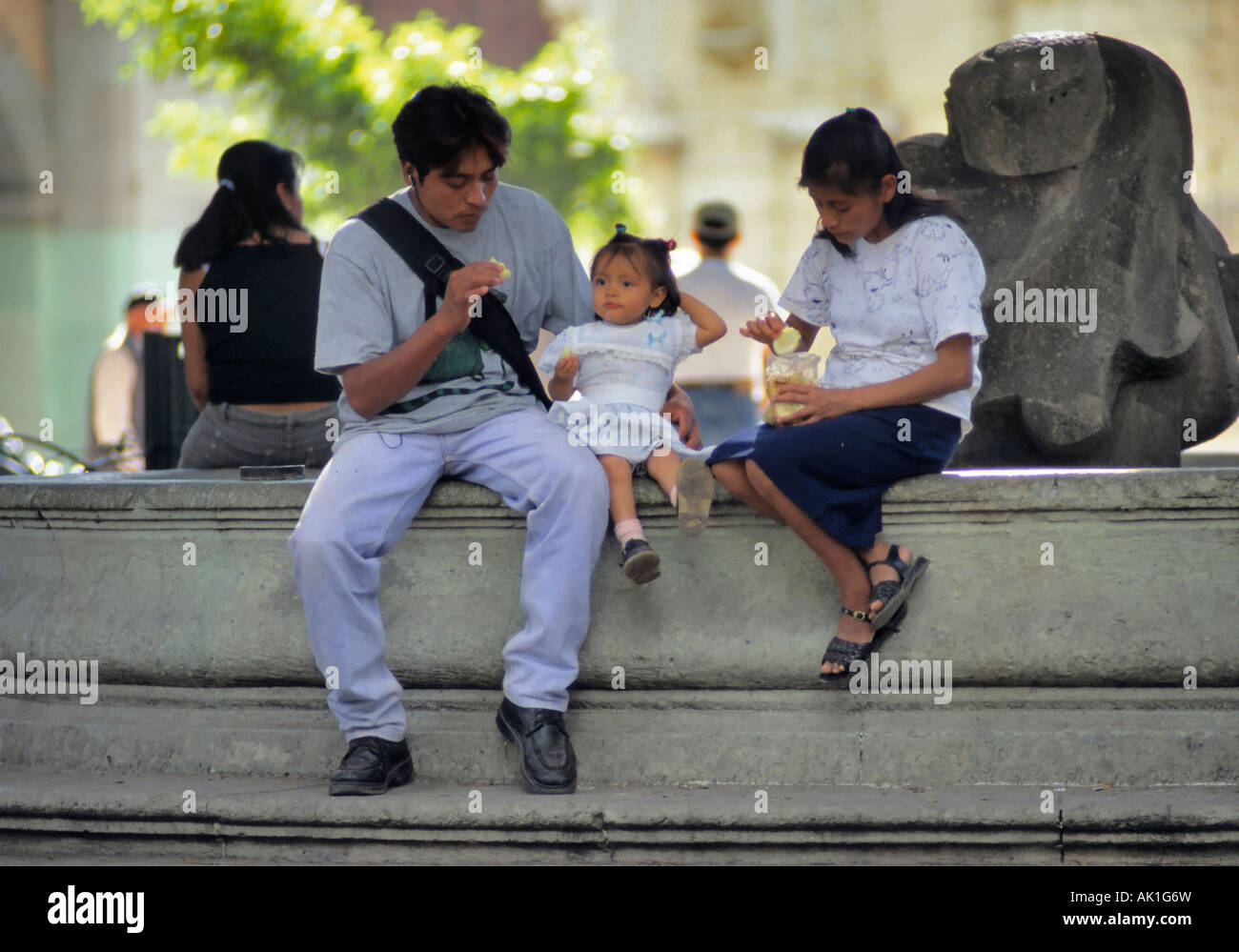 Family sitting at fountain at Zocalo in Oaxaca, Mexico Stock Photo