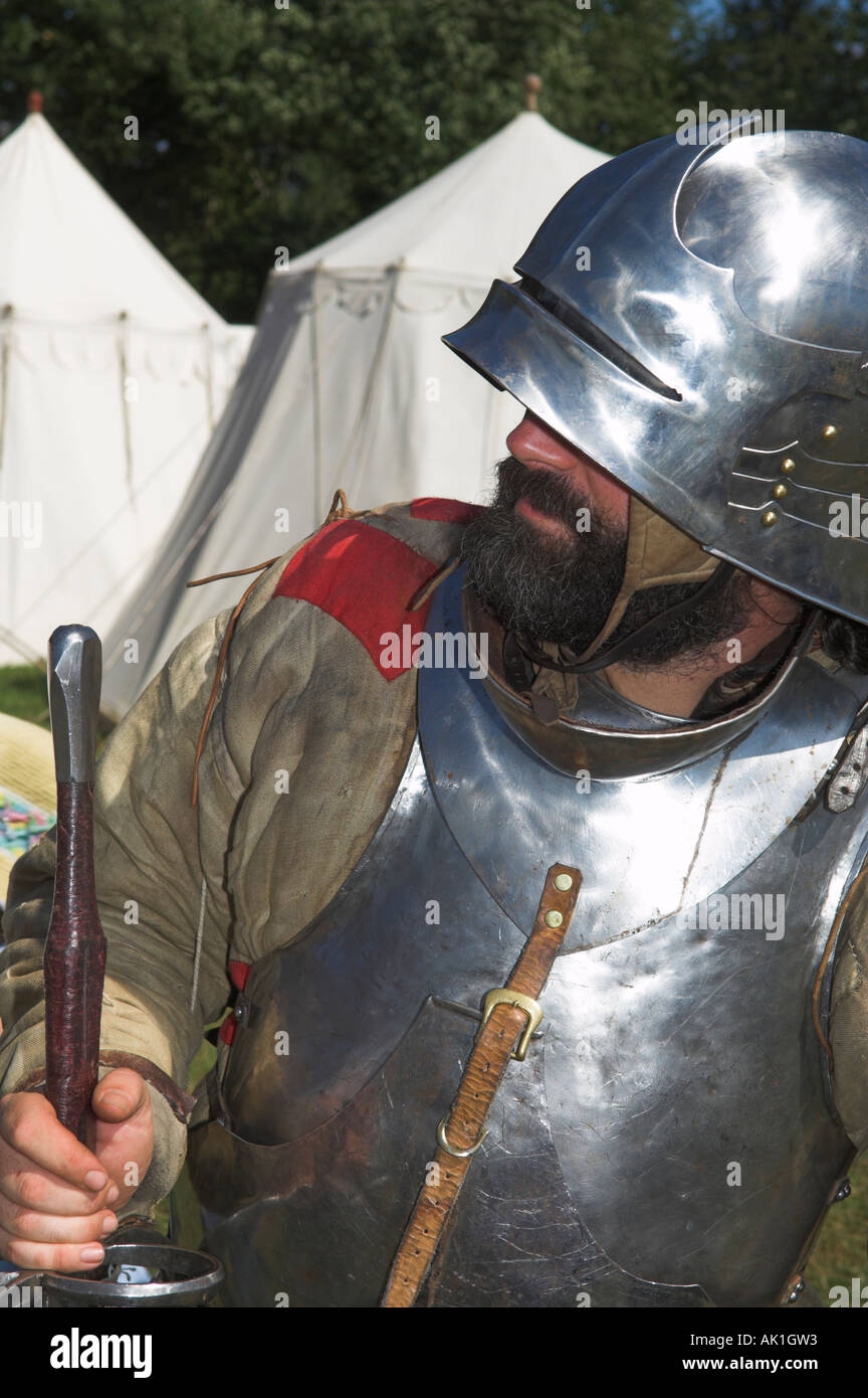 Closeup of man in suit of shining armour holding pike at medieval reenactment Stock Photo