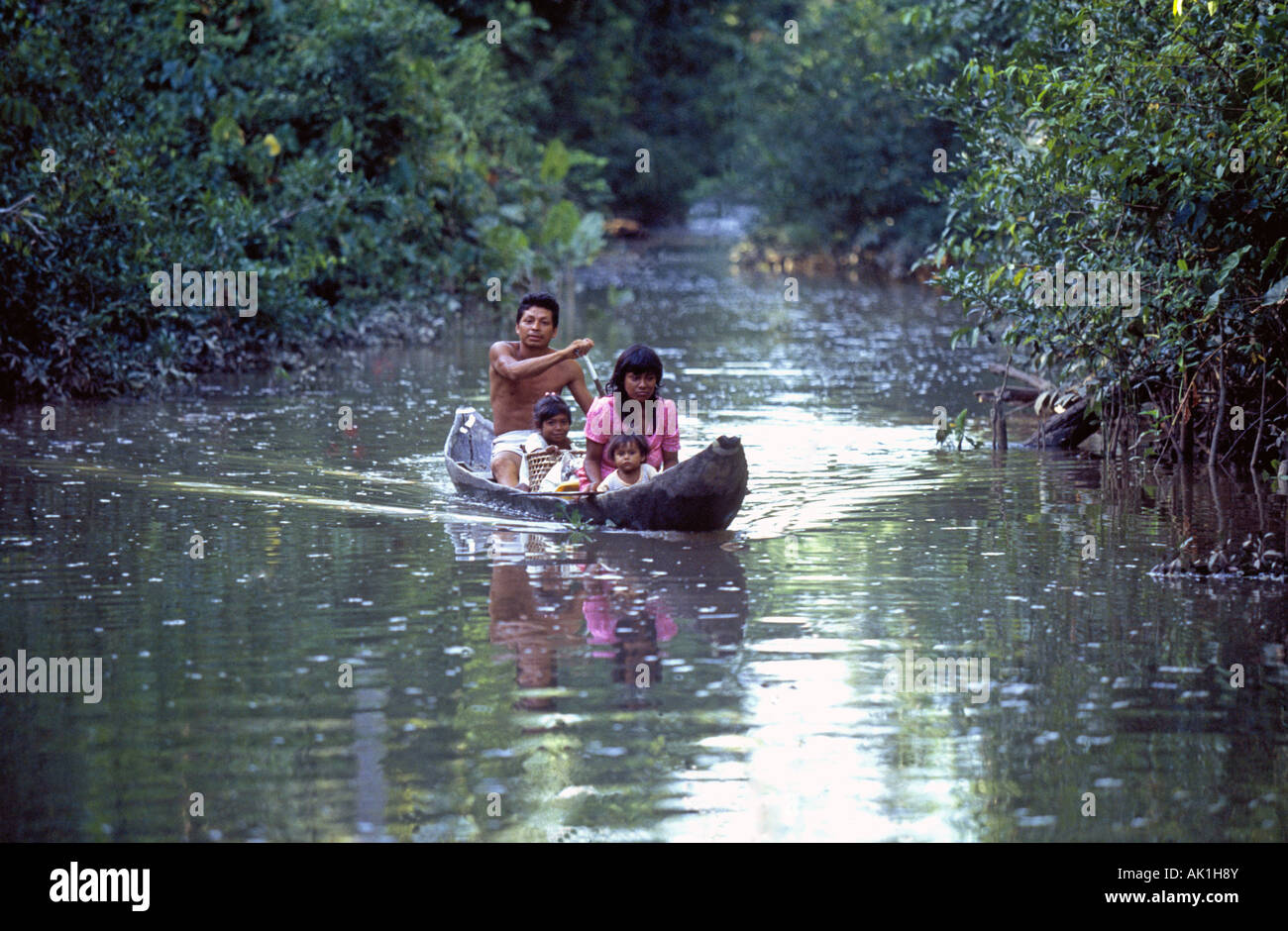 A dugout canoe filled with a Pemon  Indian family on the Orinoco River in Venezuela Stock Photo