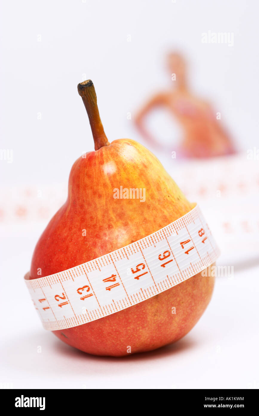 Overweight check-up (Red pear, blur woman on background) Stock Photo