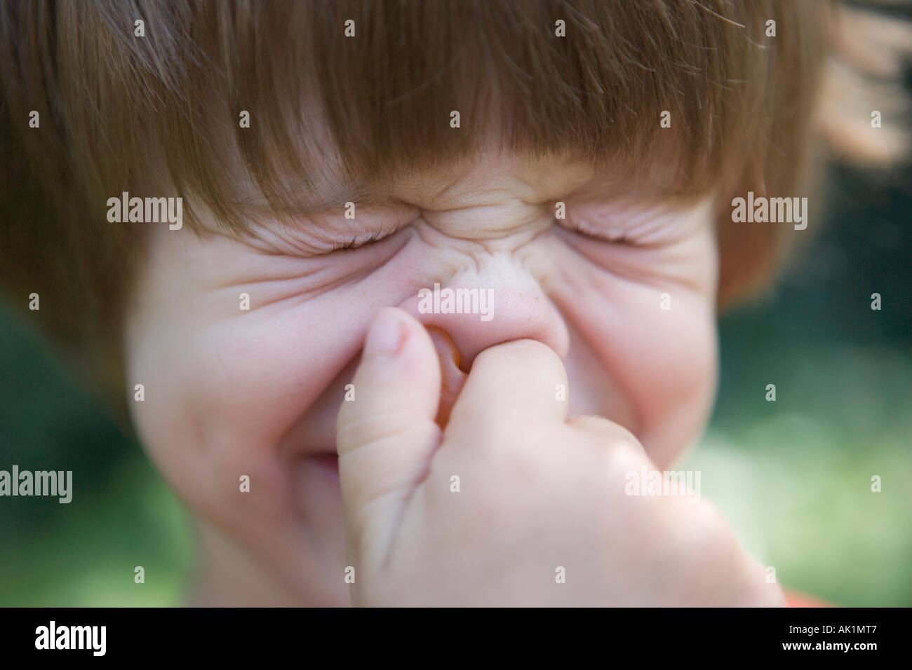 child holding nose and squinting Stock Photo