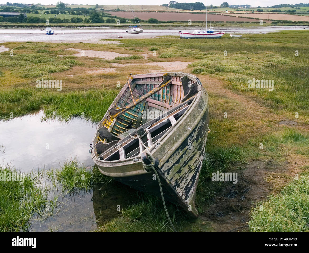 A derelict old wooden fishing boat lying on rough grass at Alnmouth ...
