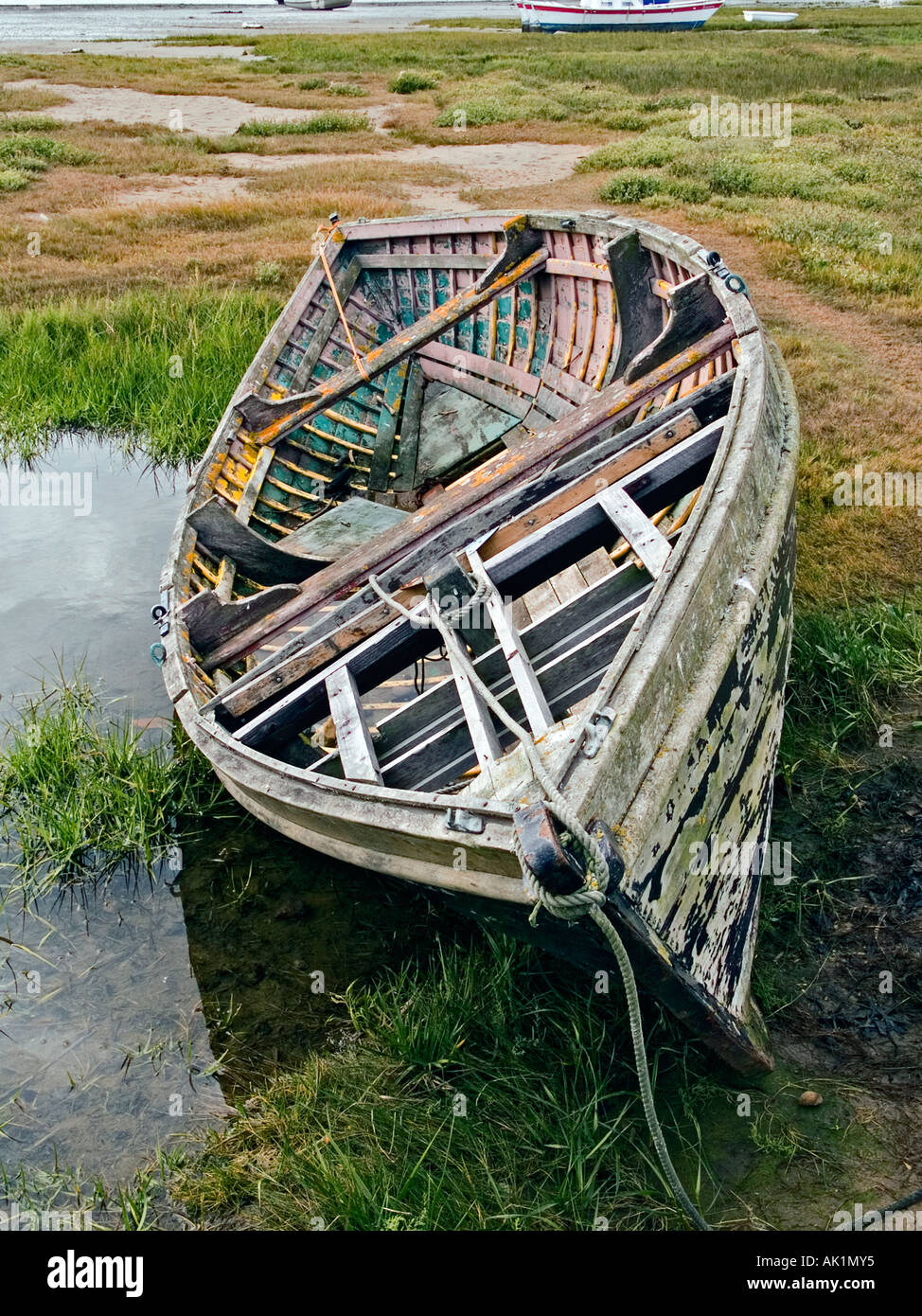 A derelict old wooden fishing boat lying on rough grass at Alnmouth ...