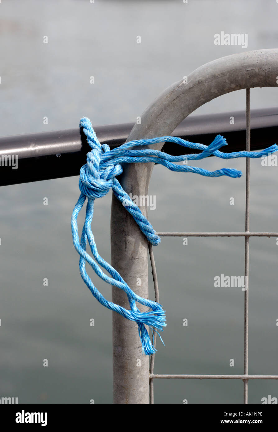 Detail of plastic rope tying metal fence to railing Stock Photo - Alamy