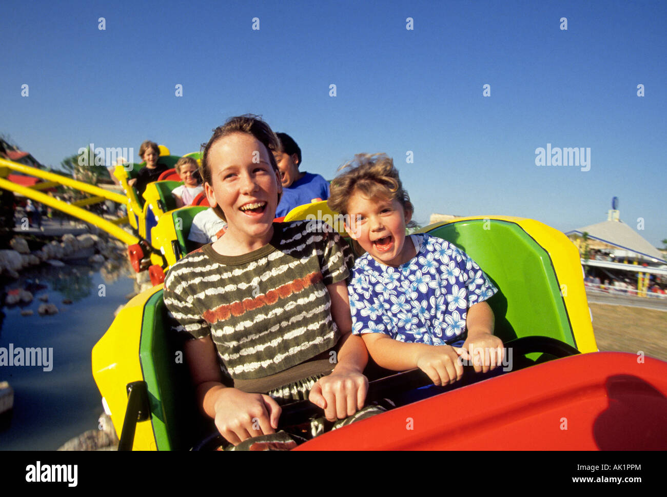 Two children scream with joy during a roller coaster ride at Fiesta Texas a large themepark Stock Photo