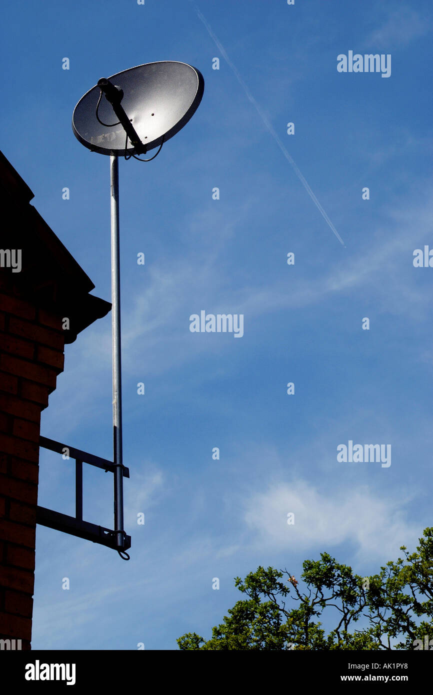 Satellite dish antenna  attached to the side of a house. Stock Photo