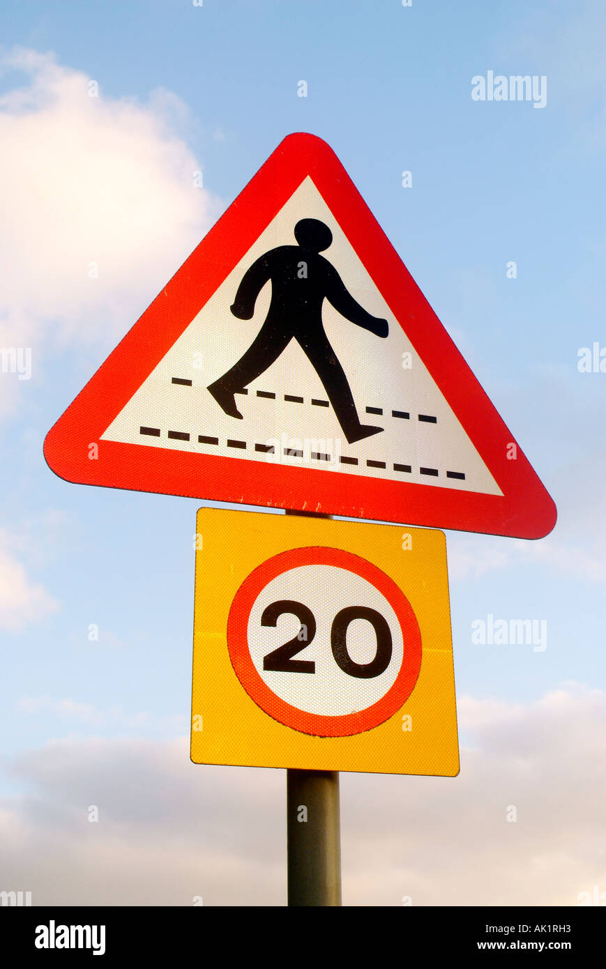 A road sign warning against pedestrians walking on crossings limits speed of vehicles to 20mph Miles Per Hour Stock Photo