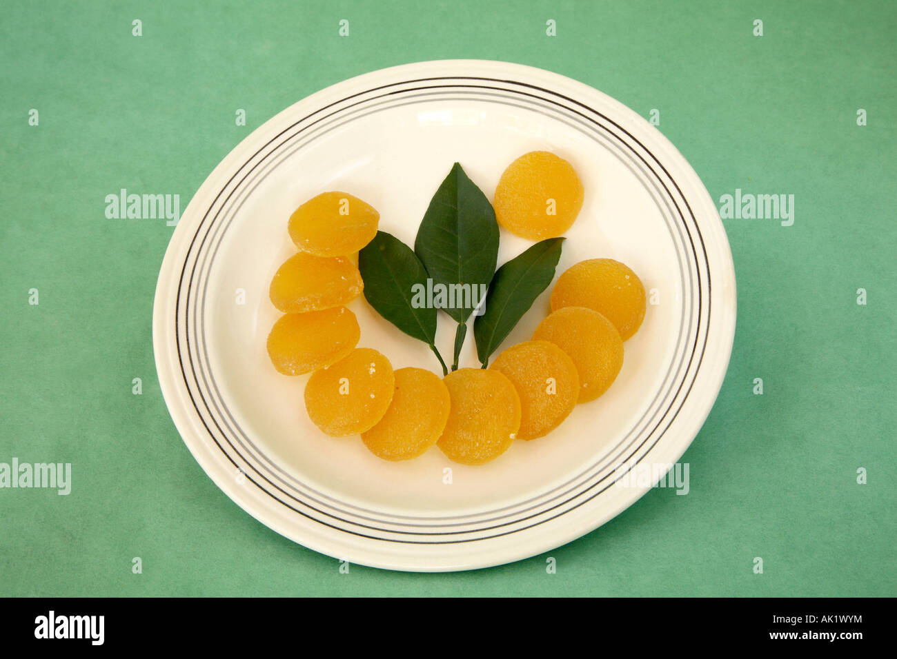 Crescent or half circle of lemon yellow circular candies with sprig of