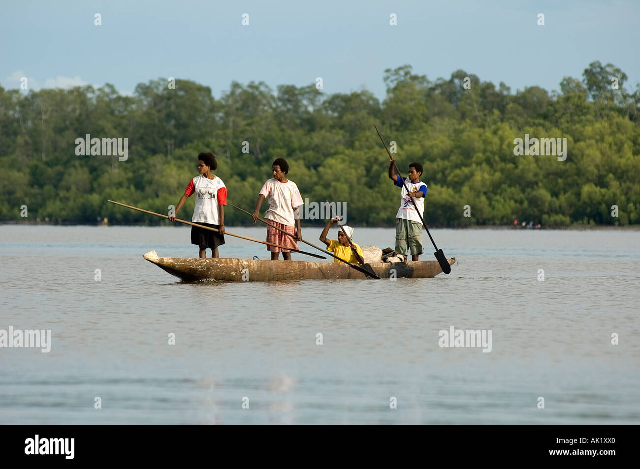 Asmat women paddling in their dugout canoe, Irian Jaya Indonesia. Stock Photo