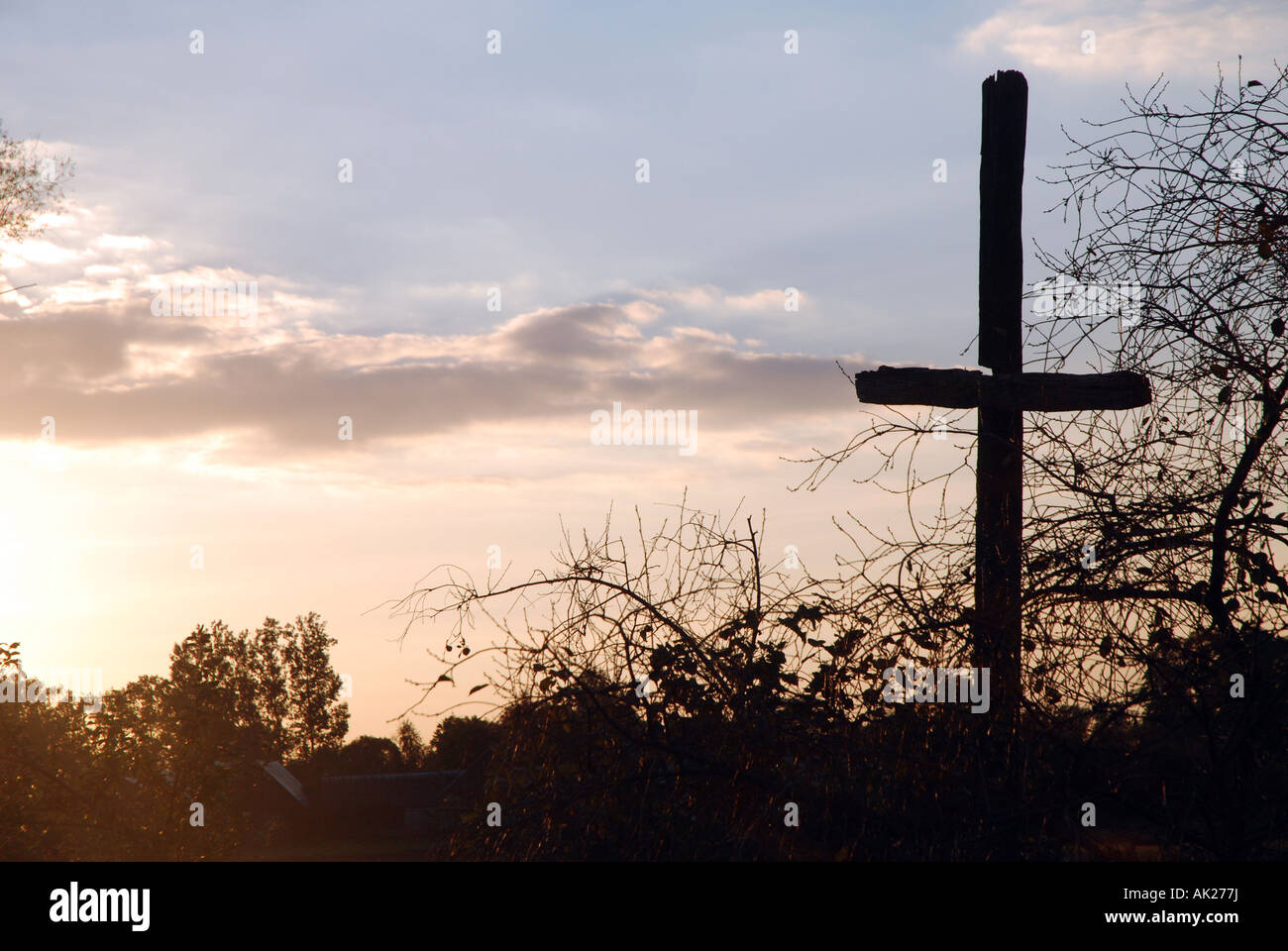 An old wooden cross standing next to countryside raod in Poland Stock Photo