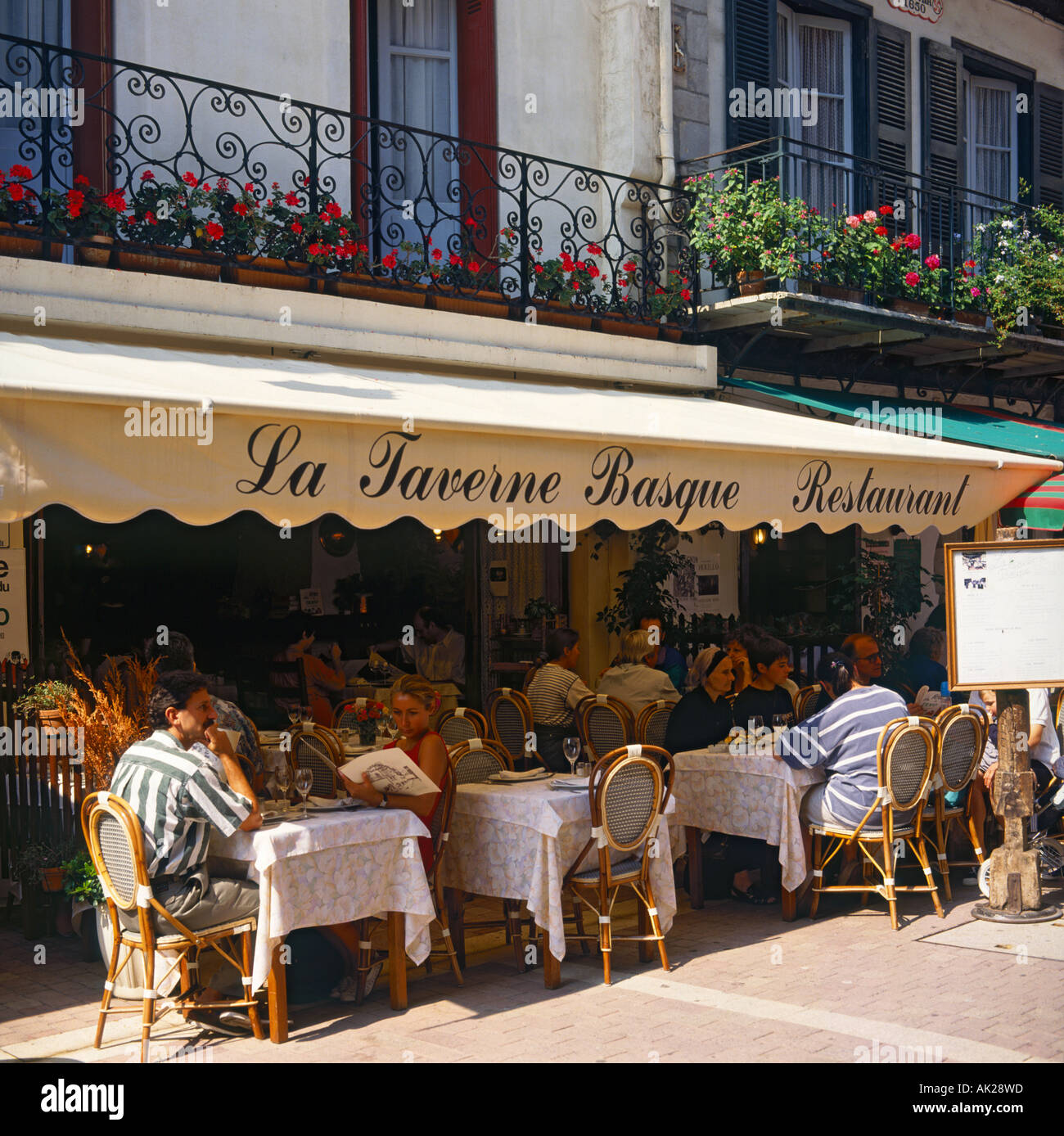 A typical French scene of people dining out doors at La Taverne Basque  Restaurant St Jean-de-Luz France Stock Photo - Alamy