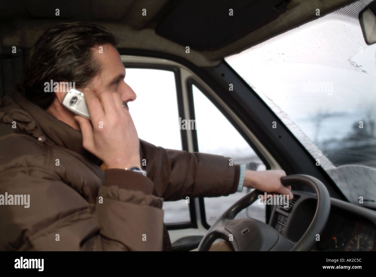 Man talks on mobile phone while driving Stock Photo