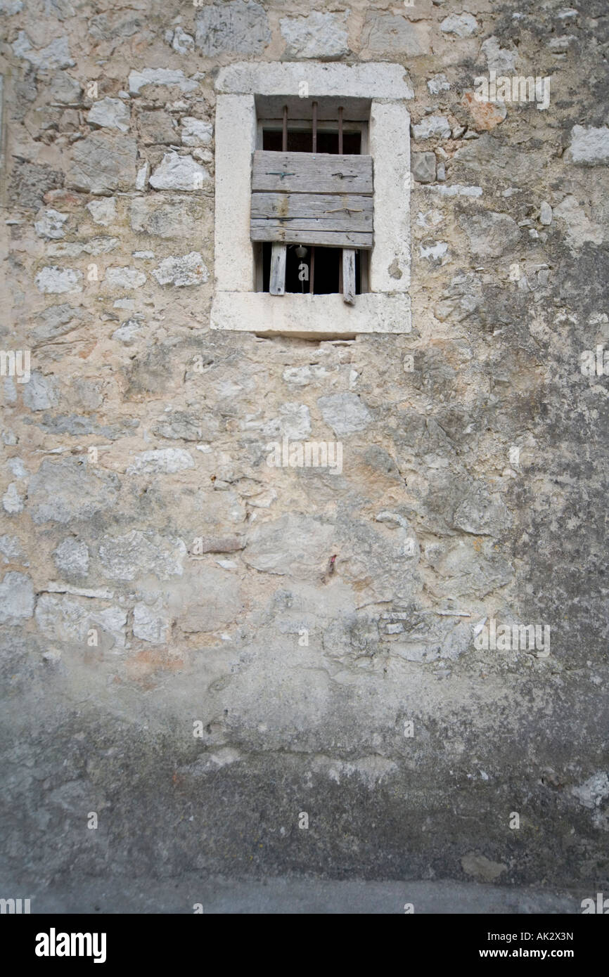 Detail of barred window in wall of ancient village of Pitve Hvar Croatia balkans Stock Photo