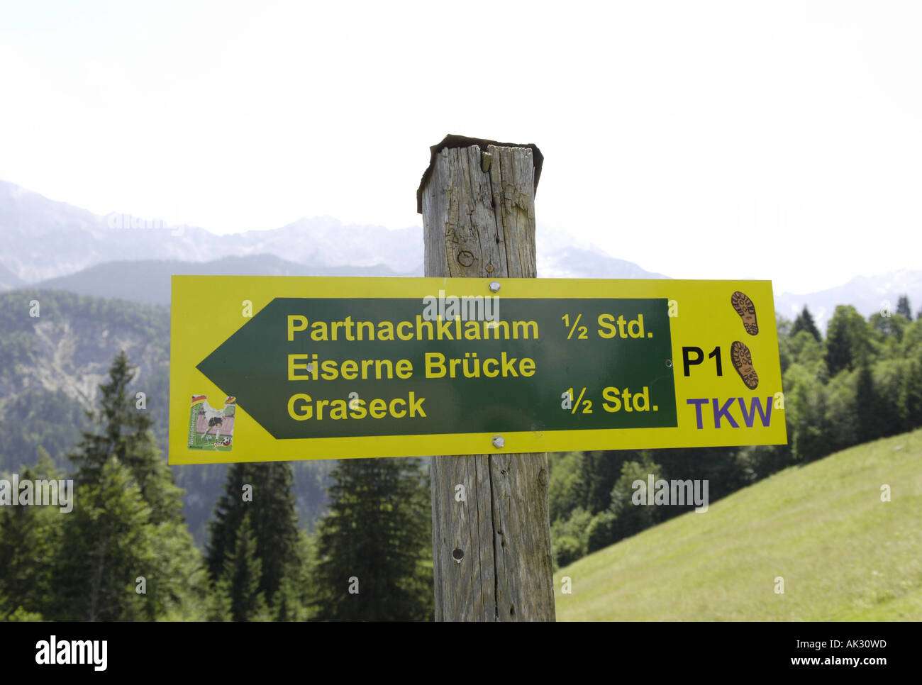 partnachklamm eiserne brucke graseck trail sign signpost green yellow nature natural rural coutnryside  alpine trail trek hike g Stock Photo