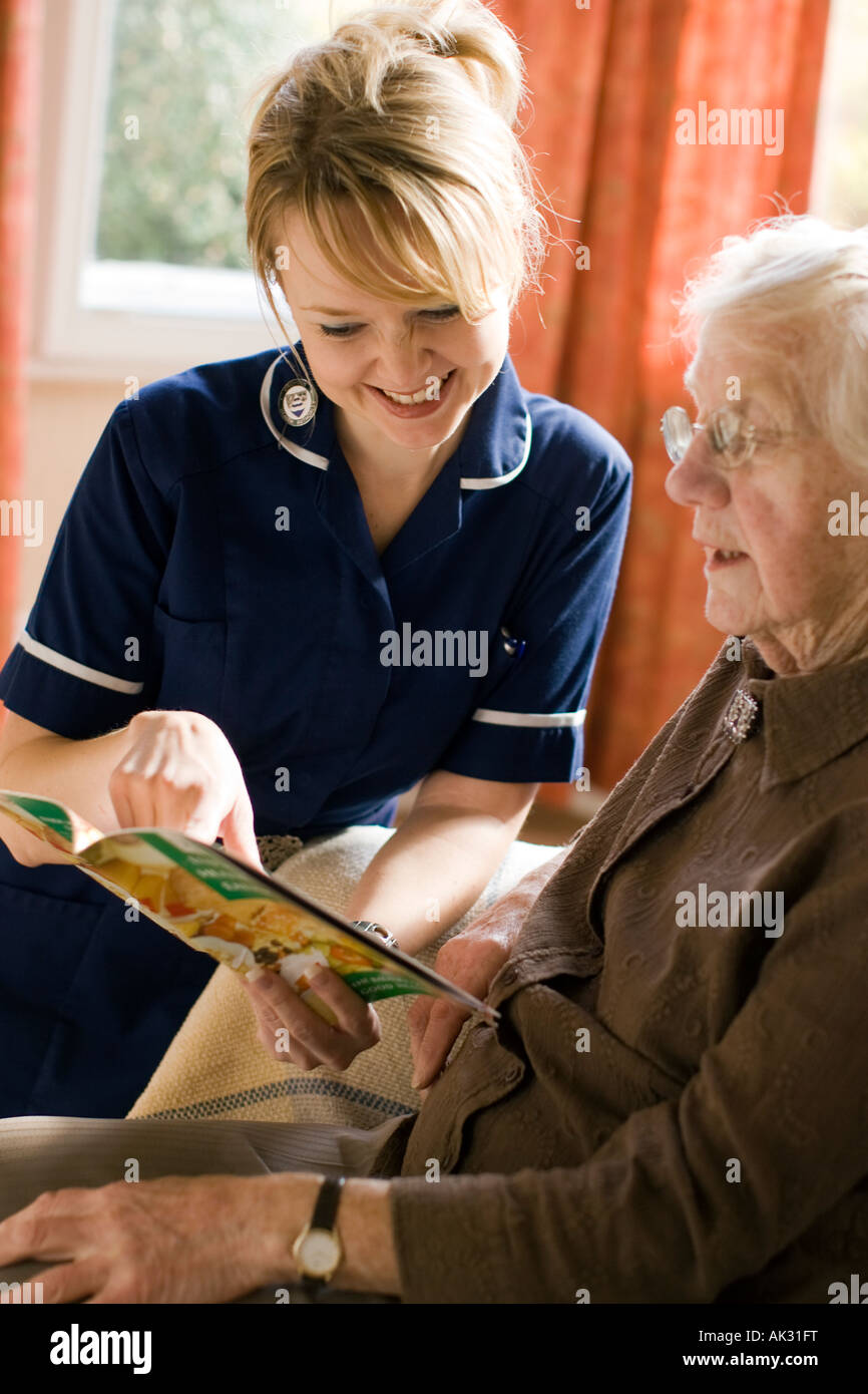District nurse giving advice on home visit Stock Photo