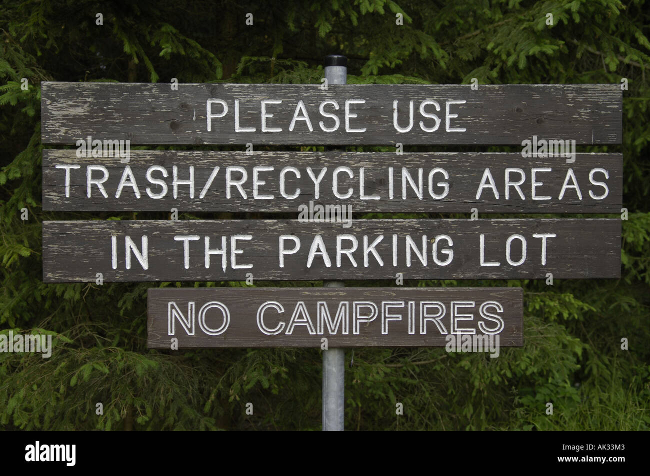 please use trash recycling areas in the parking lot  no campfires camping campsite regulations rules american base wood wooden s Stock Photo