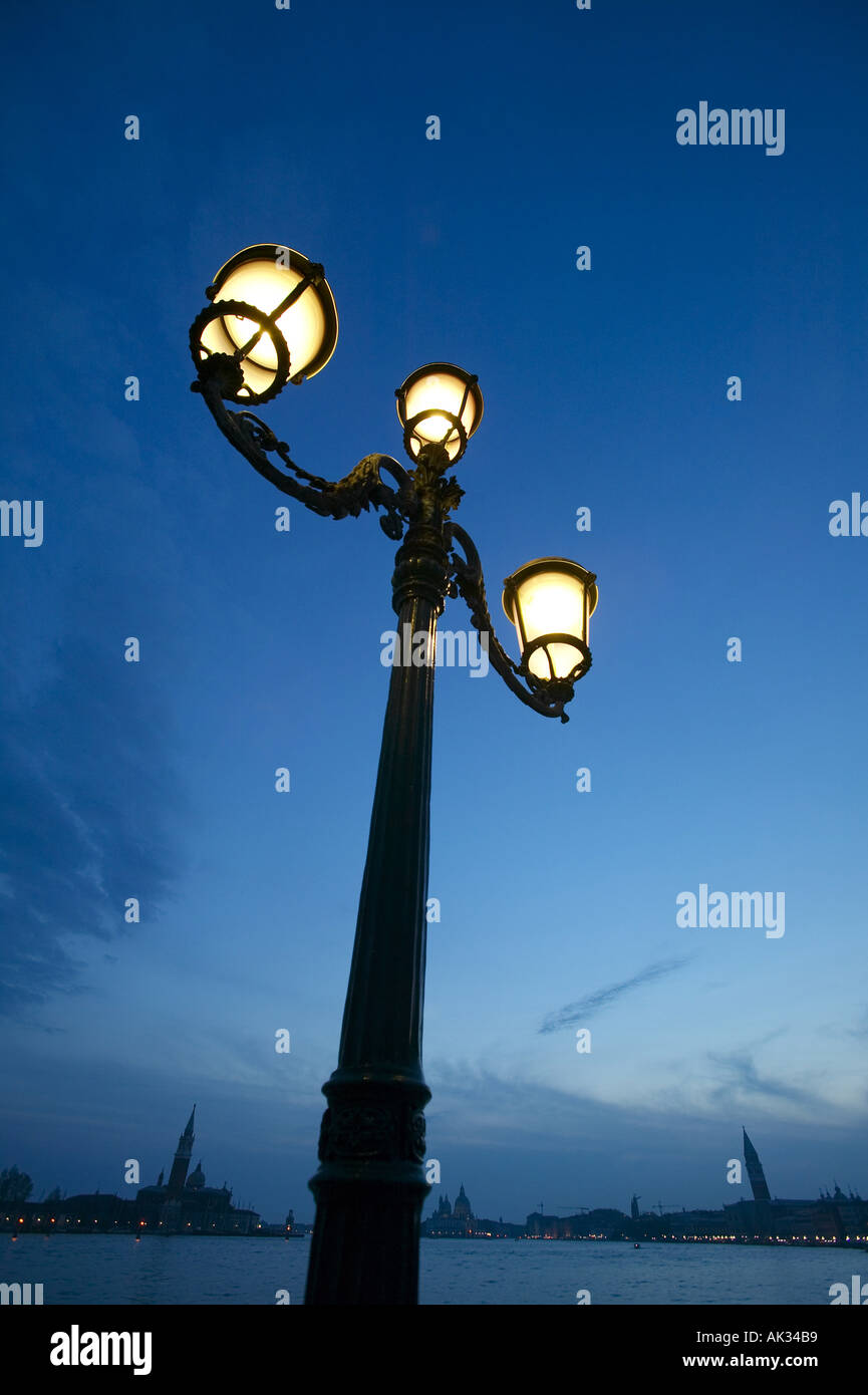 Streetlight by edge of water at dusk uid 1433820 Stock Photo