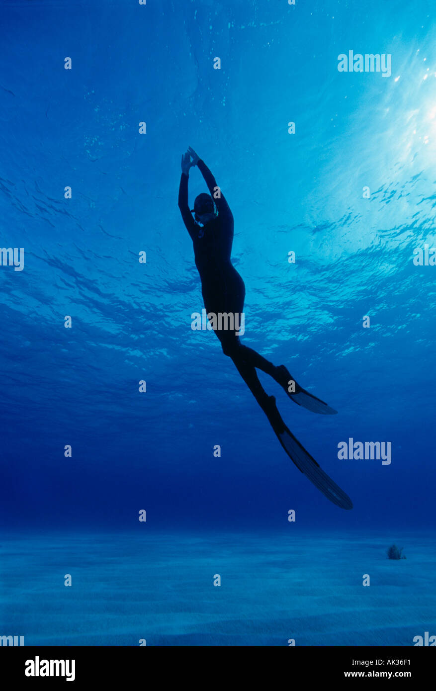 Woman freediver ascending underwater Stock Photo