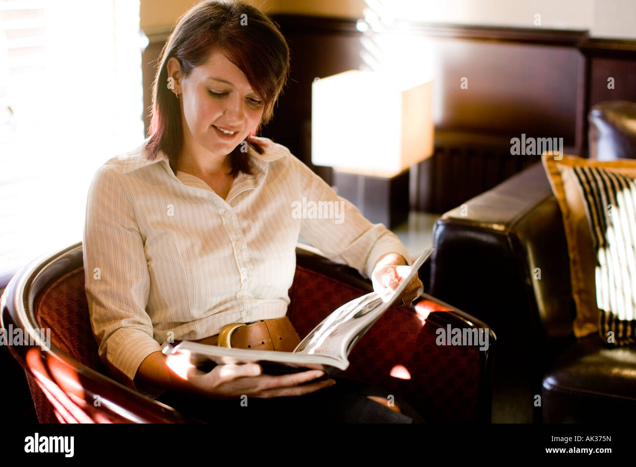 Woman reading magazine in hotel Stock Photo