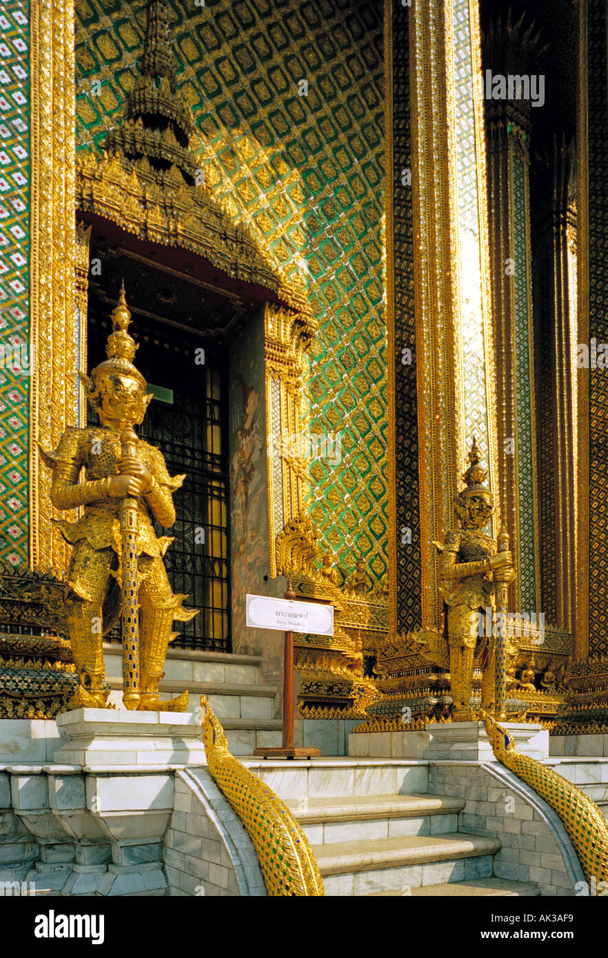 Royal Grand Palace Bangkok Thailand - Golden garudas guard the entrance to the royal pantheon holding statues of former kings of Thailand Stock Photo